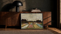 colorful tulip fields with farmhouses vintage art print print in a black frame leaning against a walnut console in lamplight