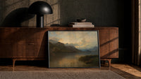 mountain lake at sunset with rowboat vintage art print print in a black frame leaning against a walnut console in lamplight