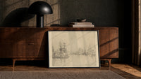 tall ships in a harbor vintage art print print in a black frame leaning against a walnut console in lamplight