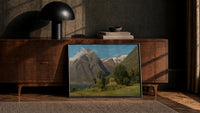 Norwegian fjord and mountain lake landscape vintage art print print in a black frame leaning against a walnut console in…
