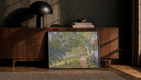 sun-dappled garden path beside a cottage vintage art print print in a black frame leaning against a walnut console in…