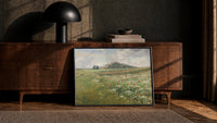 spring meadow with wild poppies and daisies vintage art print print in a black frame leaning against a walnut console in…