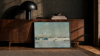 waves breaking on shore vintage art print print in a black frame leaning against a walnut console in lamplight