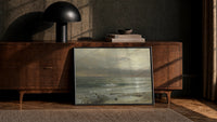 stormy ocean waves at dusk with seabirds vintage art print print in a black frame leaning against a walnut console in…