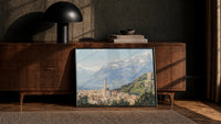 Italian hillside village below snow-capped Alps vintage art print print in a black frame leaning against a walnut console…