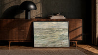stormy grey-green seascape with breaking waves vintage art print print in a black frame leaning against a walnut console…