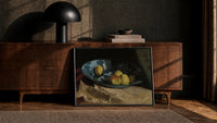 apples and quince in a porcelain bowl vintage art print print in a black frame leaning against a walnut console in lamplight