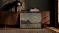 fjord/lake with dramatic clouds vintage art print print in a black frame leaning against a walnut console in lamplight