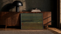 figures on a beach before crashing surf vintage art print print in a black frame leaning against a walnut console in…