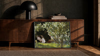 woman reading under white roses with a sleeping dog vintage art print print in a black frame leaning against a walnut…