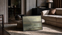 stormy ocean waves at dusk with seabirds vintage art print print in a slim black frame leaning on a travertine coffee table
