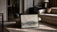 Parisian bridge and riverside architecture vintage art print print in a slim black frame leaning on a travertine coffee table