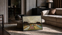 colorful tulip fields with farmhouses vintage art print print in a slim black frame leaning on a travertine coffee table