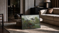 flowering garden with a cottage vintage art print print in a slim black frame leaning on a travertine coffee table