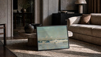 waves breaking on shore vintage art print print in a slim black frame leaning on a travertine coffee table