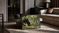 woman reading under white roses with a sleeping dog vintage art print print in a slim black frame leaning on a travertine…