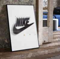 Nike Just Do It Swoosh framed poster print in a black frame leaning beside a vintage door on parquet