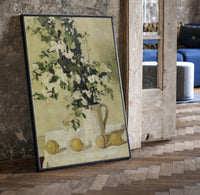 flowers and lemons still life vintage art print print in a black frame leaning beside a vintage door on parquet
