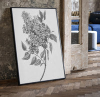 flowering lilac branch vintage art print print in a black frame leaning beside a vintage door on parquet