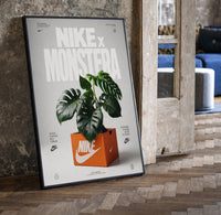 Nike Monstera Sneaker Box Green framed poster print in a black frame leaning beside a vintage door on parquet