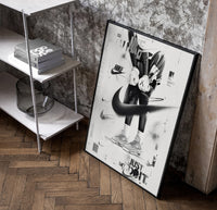 KAWS Companion Air Jordan Sneakers framed poster poster in a black frame leaning beside a shelf in a raw-plaster loft