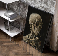 skeleton smoking a cigarette vintage art print poster in a black frame leaning beside a shelf in a raw-plaster loft