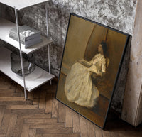 seated woman in white dress vintage art print poster in a black frame leaning beside a shelf in a raw-plaster loft