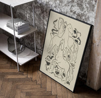 three horses vintage art print poster in a black frame leaning beside a shelf in a raw-plaster loft
