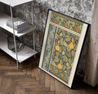 Art Nouveau botanical pattern with gourds and flowers vintage art print poster in a black frame leaning beside a shelf in…