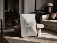 female face portrait study vintage art print print in a black frame leaning on a travertine table in a sunlit lounge
