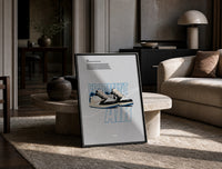 Travis Scott x Fragment Air Jordan 1 framed poster print in a black frame leaning on a travertine table in a sunlit lounge