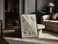 three horses vintage art print print in a black frame leaning on a travertine table in a sunlit lounge