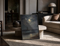 tall ship at sea under full moon vintage art print print in a black frame leaning on a travertine table in a sunlit lounge