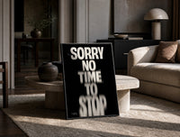 Sorry No Time To Stop print on the floor, leaning against a travertine table