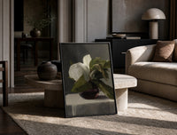 white peony in dark glass vase vintage art print print in a black frame leaning on a travertine table in a sunlit lounge