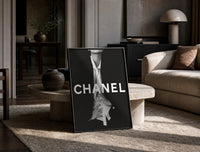 Chanel Black & White Luxury print on the floor, leaning against a travertine table