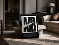 Nike Air History framed poster print in a black frame leaning on a travertine table in a sunlit lounge