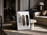 Saint Laurent Cest La Vie Skateboards framed poster print in a black frame leaning on a travertine table in a sunlit lounge