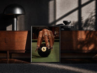 Black-framed Hand on the Eight Ball print on the floor in front of a dark wooden console