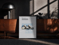 Black-framed Travis Scott x Fragment Air Jordan 1 framed poster print on a moody console with designer coffee-table books