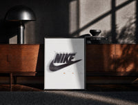 Black-framed Nike Just Do It Swoosh framed poster print on a moody console with designer coffee-table books