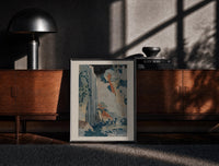 Black-framed Hokusai Ono Waterfall Kiso Road print on the floor in front of a dark wooden console