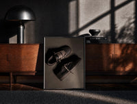 Black-framed Air Jordan 1 x Travis Scott Velvet Brown Mocha print on the floor in front of a dark wooden console