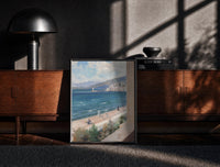 Black-framed Mediterranean coastal promenade seen from balcony vintage art print print on a moody console with designer…