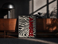 Black-framed Amore Zebra Print on the floor in front of a dark wooden console