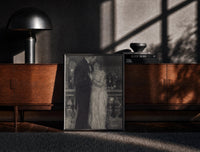 Black-framed couple embracing on a night balcony vintage art print print on a moody console with designer coffee-table books