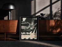 Black-framed White Off-White Nike Air Force 1 framed poster print on a moody console with designer coffee-table books