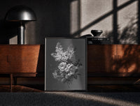 Black-framed white lilac and roses bouquet vintage art print print on a moody console with designer coffee-table books