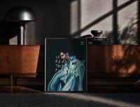 Black-framed Drake If You're Reading This It's Too Late print on the floor in front of a dark wooden console