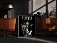Black-framed Kurt Cobain Nirvana Live print on the floor in front of a dark wooden console